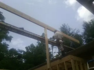 Carpenter setting a ridge beam over a new addition frame — Ice Dam Removal by Roofing Brothers in Knightdale