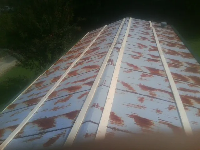 Rusted metal roof panels with new wood purlins before replacement — Storm Damage Roof Repair in Knightdale by Roofing Brothers
