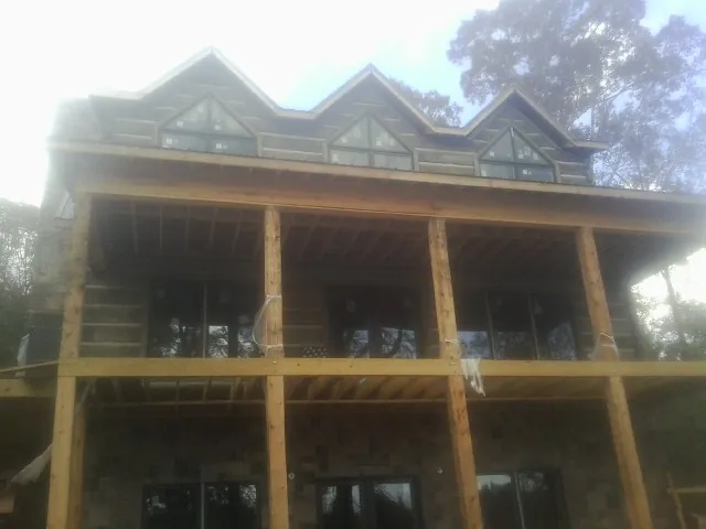 Dormers and porch framing on a large log home under construction — Roof Coating work by our crew in Knightdale
