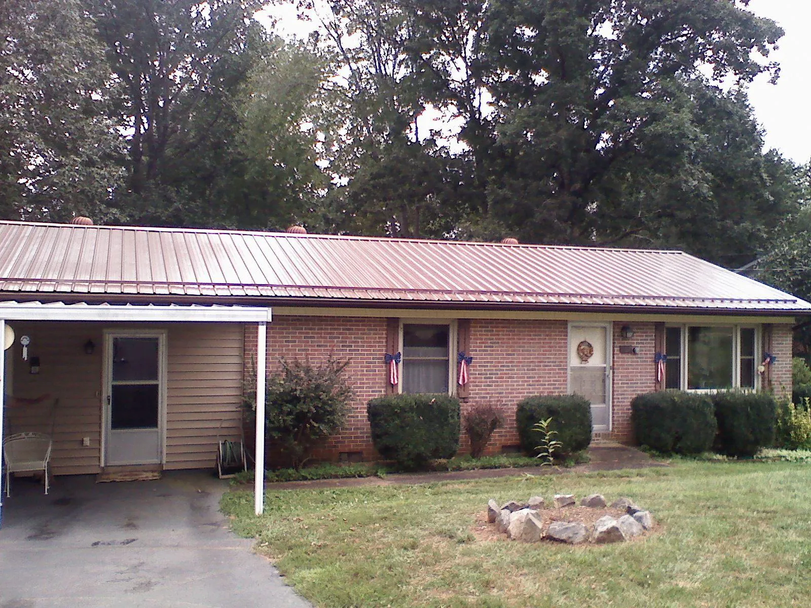 Bronze metal roof and carport on a brick ranch home — Roof Repair work by our crew in Knightdale