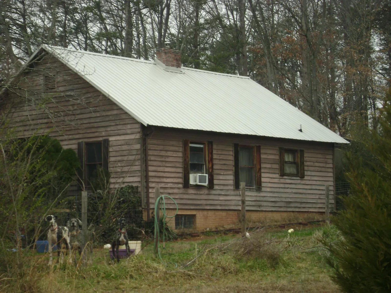 White metal roof on an old wood sided farmhouse, from a Metal Roof Installation job in Knightdale